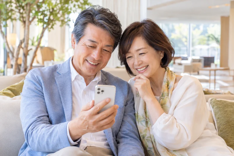 スマートフォンで結果を見て喜ぶ夫婦